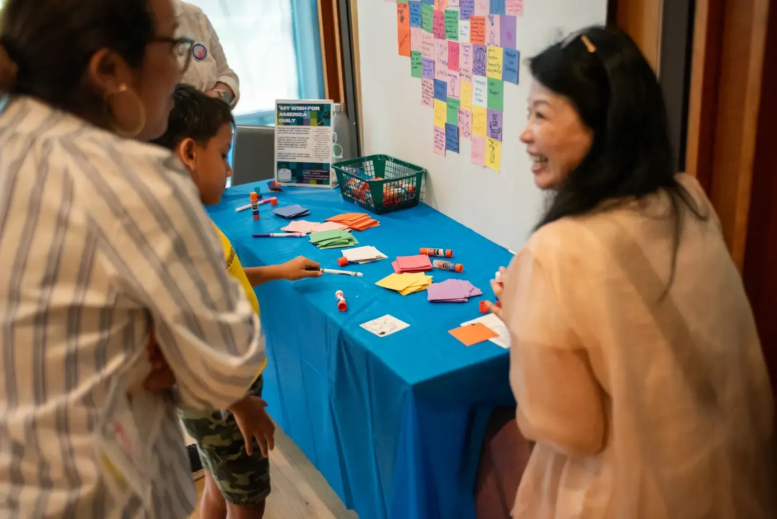 Tea setting on a table, with cups, teapot, and napkins. A window and chairs are in the background.
