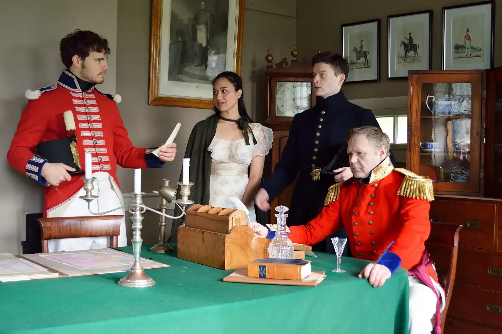 Tea setting on a table, with cups, teapot, and napkins. A window and chairs are in the background.