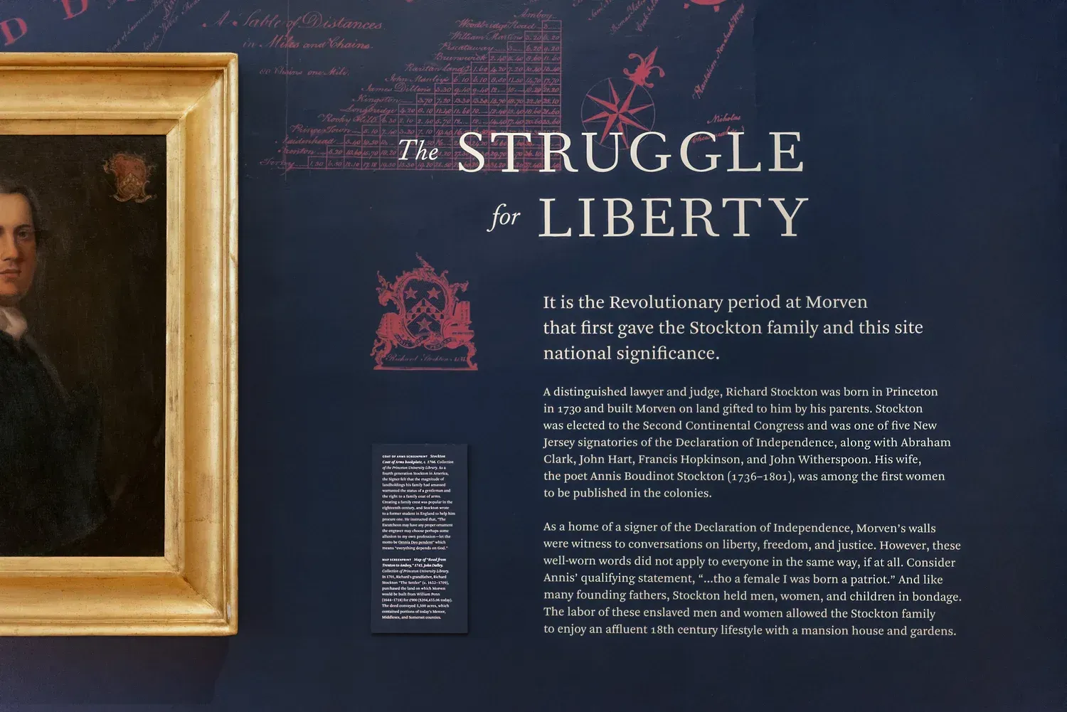 Museum exhibit: "The Struggle for Liberty" text next to a portrait. Dark blue wall, gold frame, historical context.