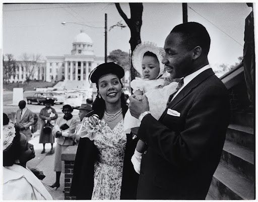 Martin Luther King Jr. with wife Coretta and baby daughter, near a capitol building.
