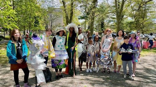 Group of people in eccentric outfits posing outdoors in a sunny park.