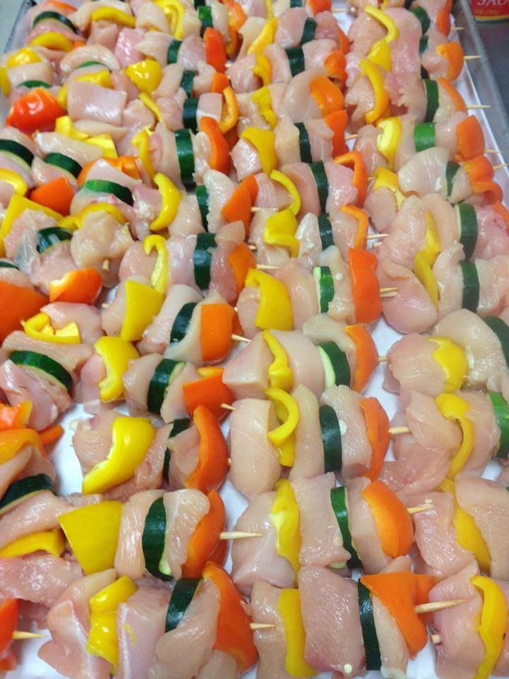 Chicken and vegetable skewers, with yellow, orange, and green bell peppers, ready to be grilled.