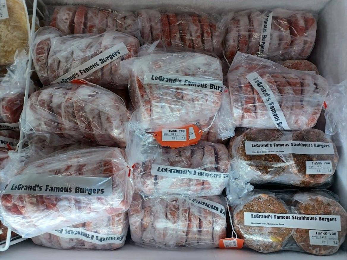 Frozen burger patties in plastic packaging inside a freezer.