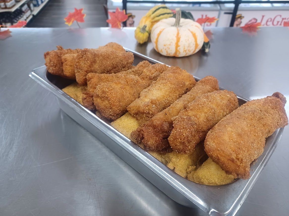 Fried food in a metal tray with a small pumpkin and gourds in the background.