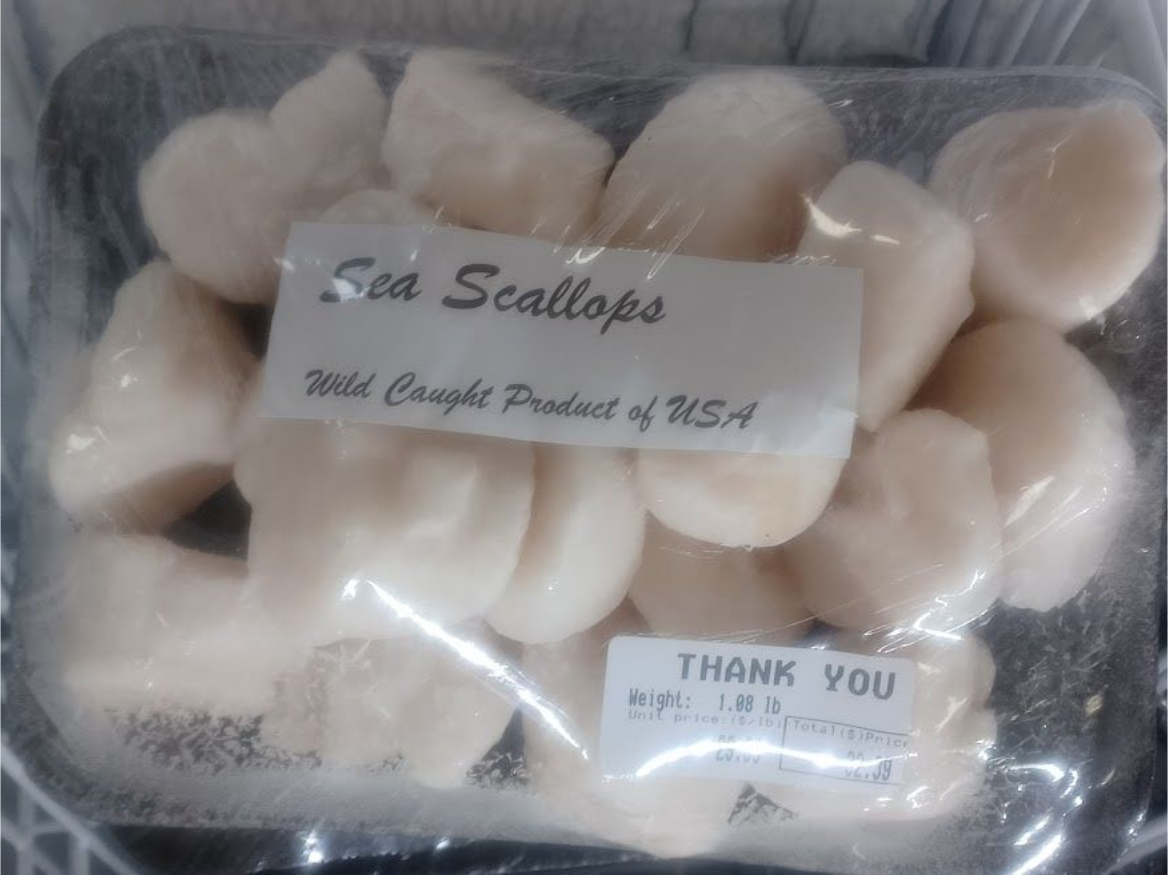 Sea scallops in a plastic-wrapped container, labeled 