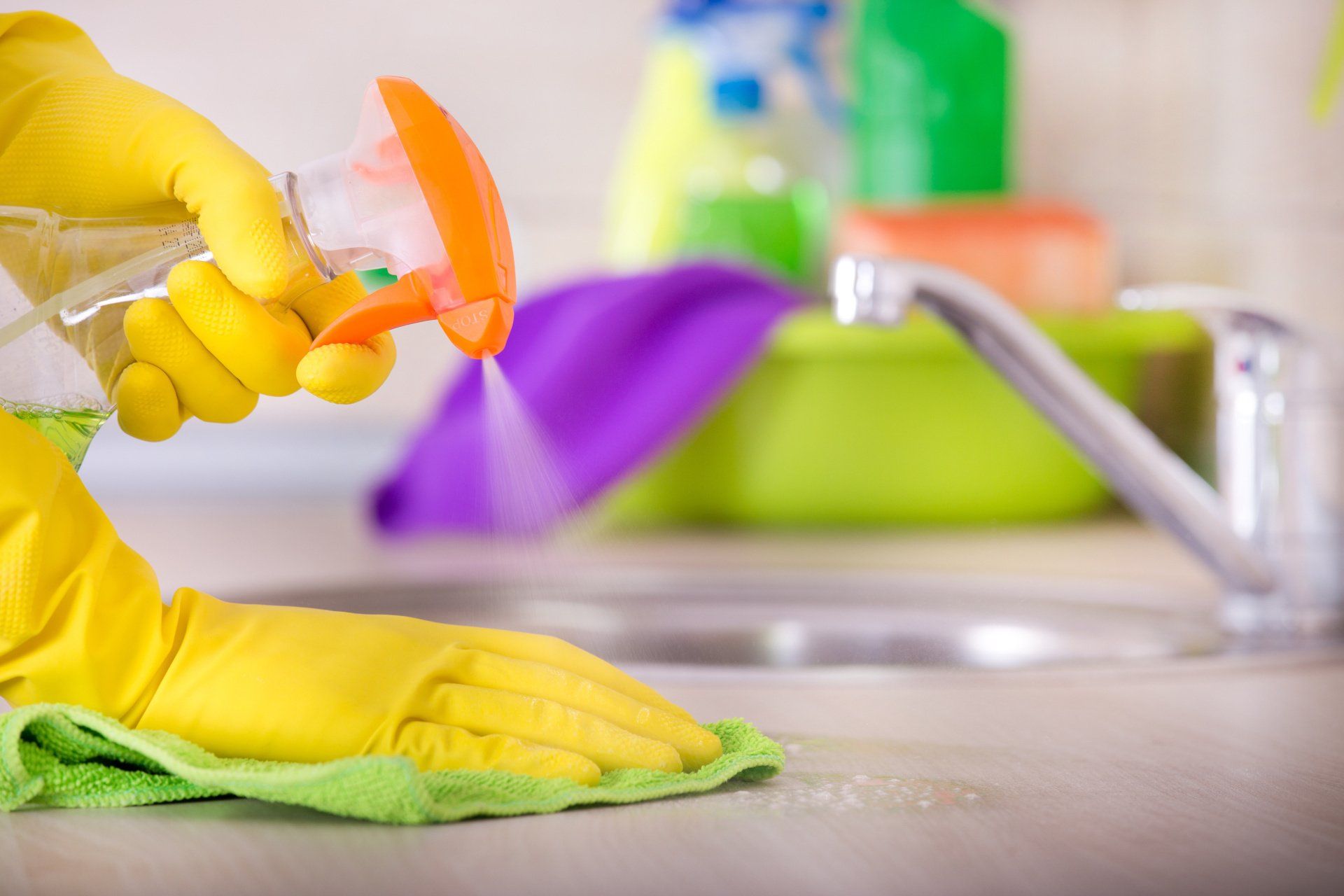 wiping down kitchen countertop with microfiber cloth