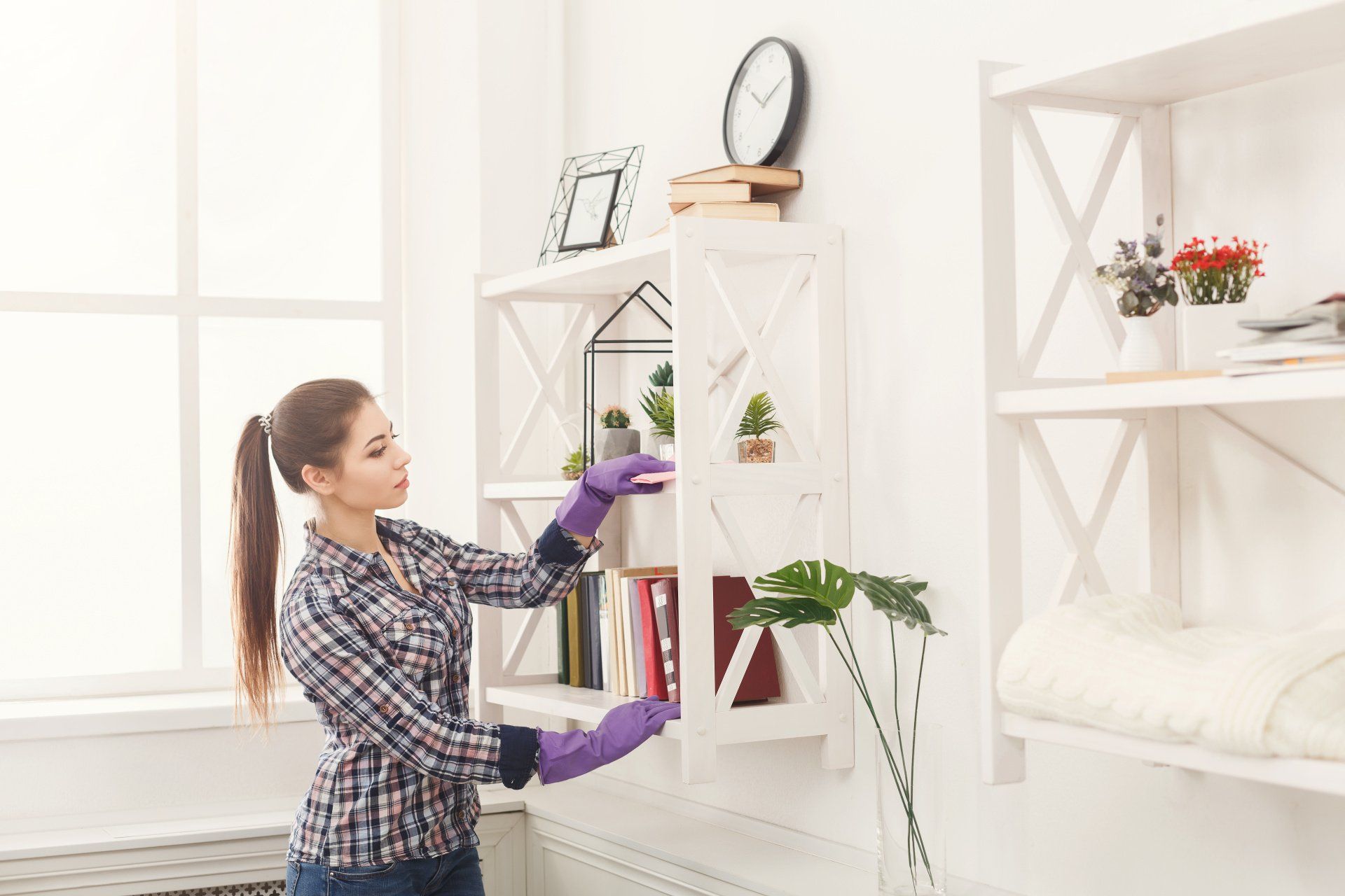a woman dusting floating shelves