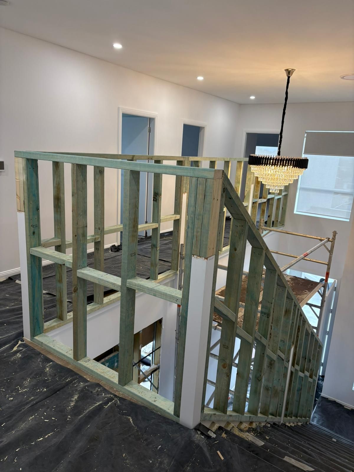 Framing of a staircase, walls under construction. Interior, unfinished home with exposed wood studs.