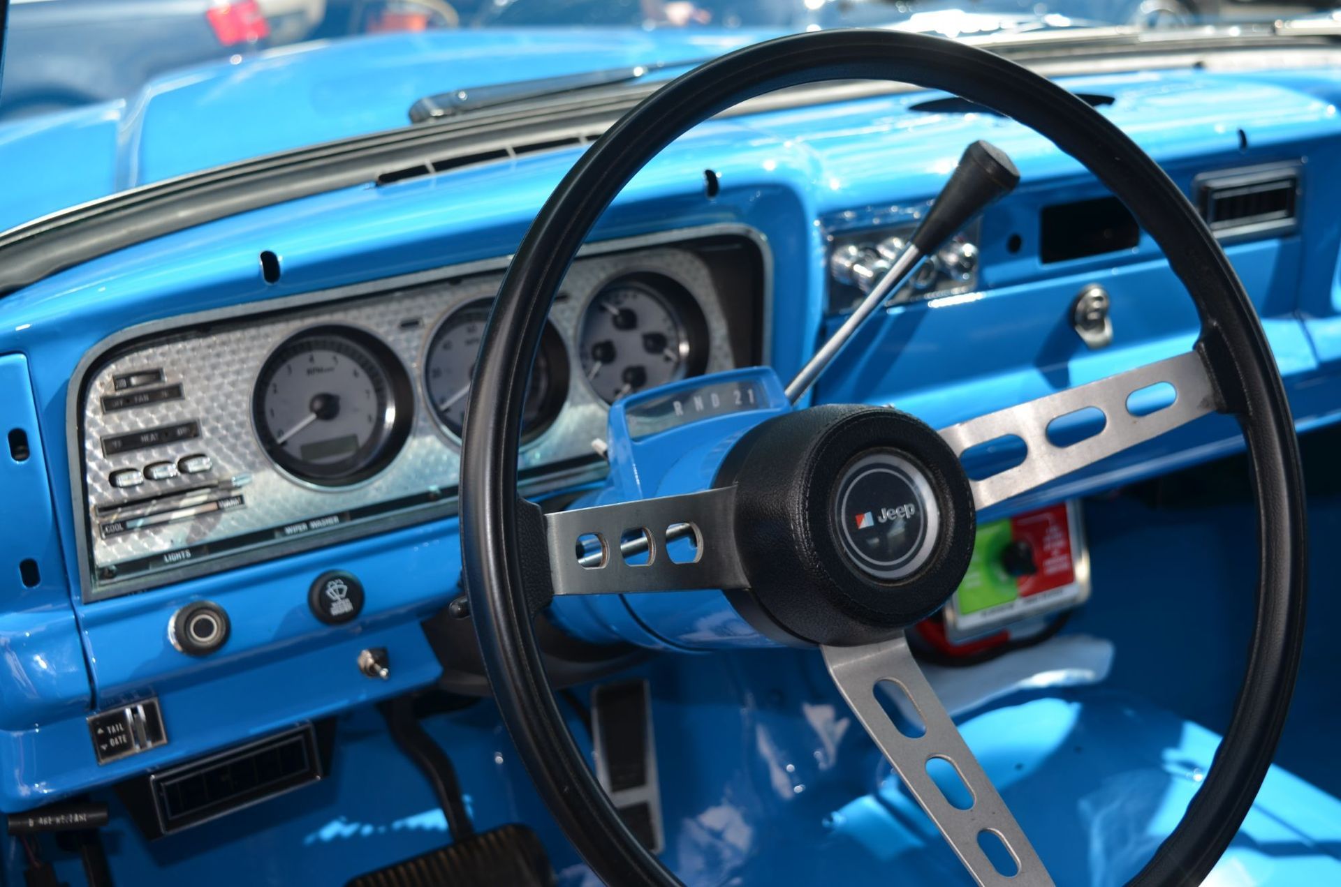 Bright blue car interior; black steering wheel with silver accents. Gauges and dashboard visible. | Autobahn Performance Inc