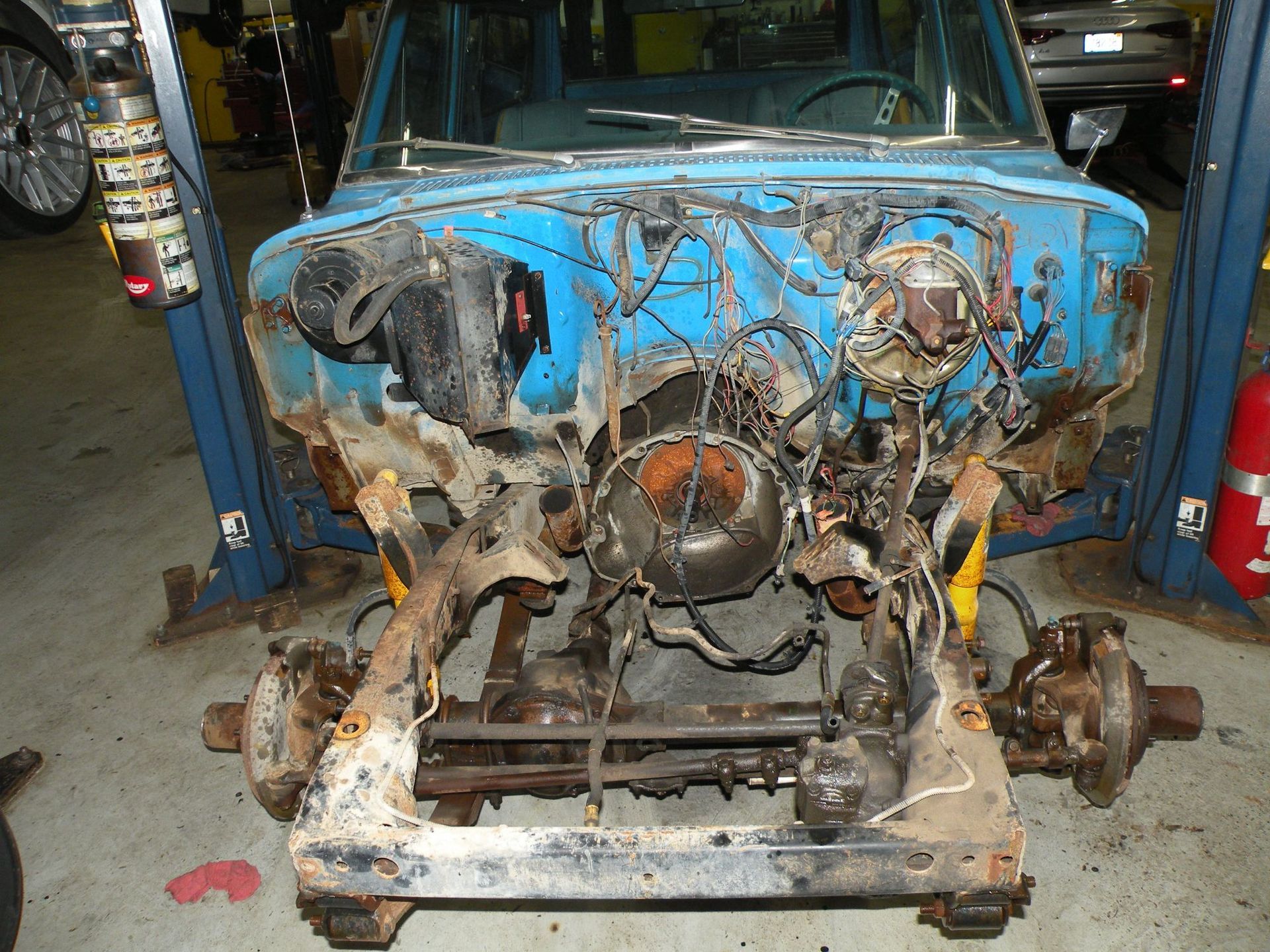 Blue classic car undergoing restoration, front end dismantled in a garage. | Autobahn Performance Inc
