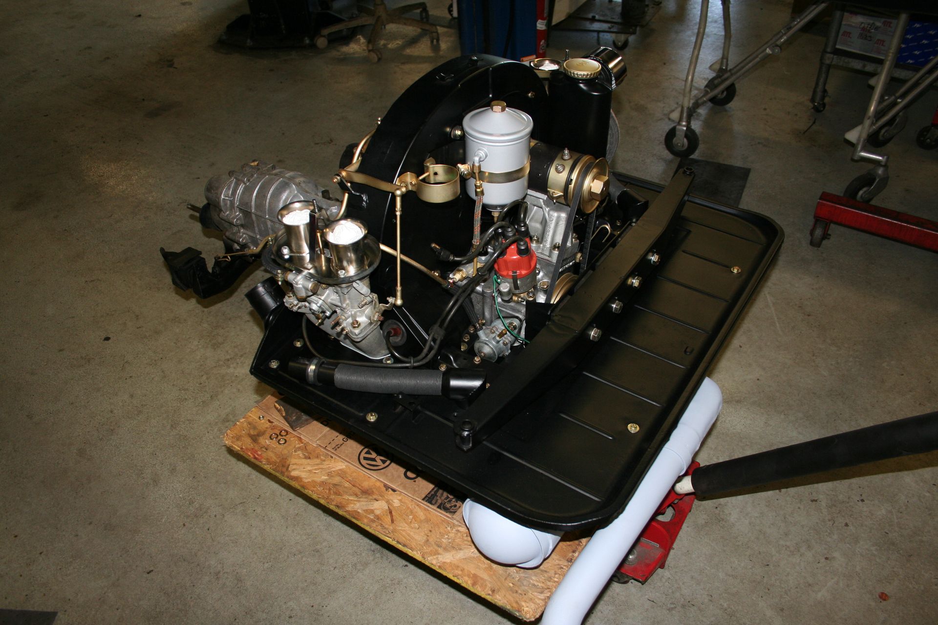 Black Porsche engine on a wooden platform, ready for installation. | Autobahn Performance Inc