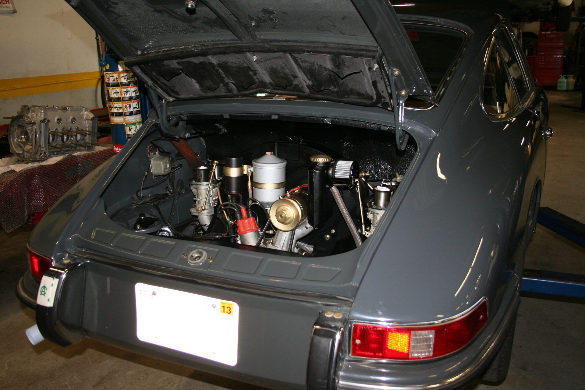 Gray Porsche 911 with engine compartment open in a garage setting. | Autobahn Performance Inc