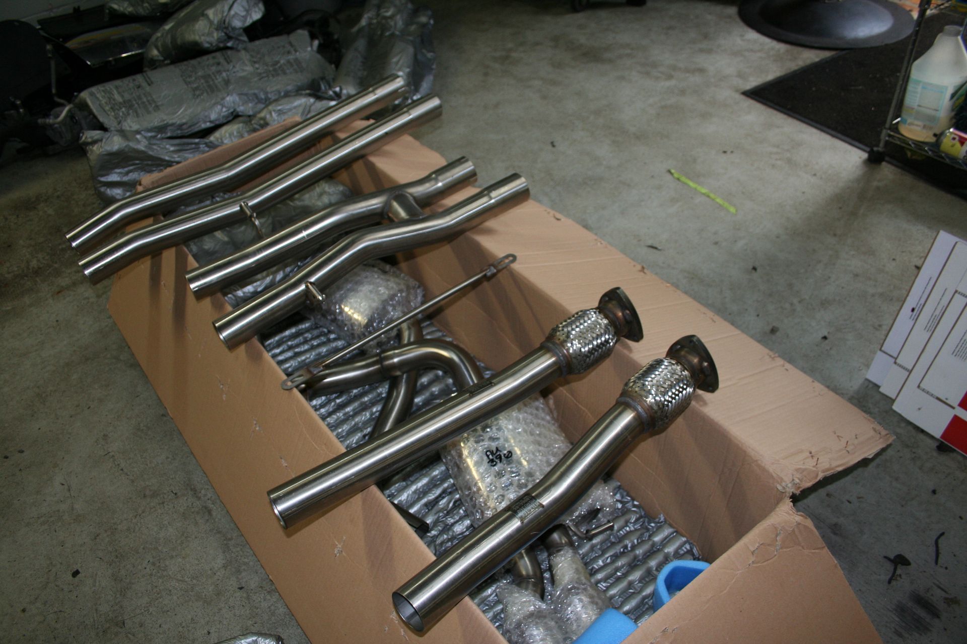 Exhaust system components in a cardboard box, ready for installation. | Autobahn Performance Inc
