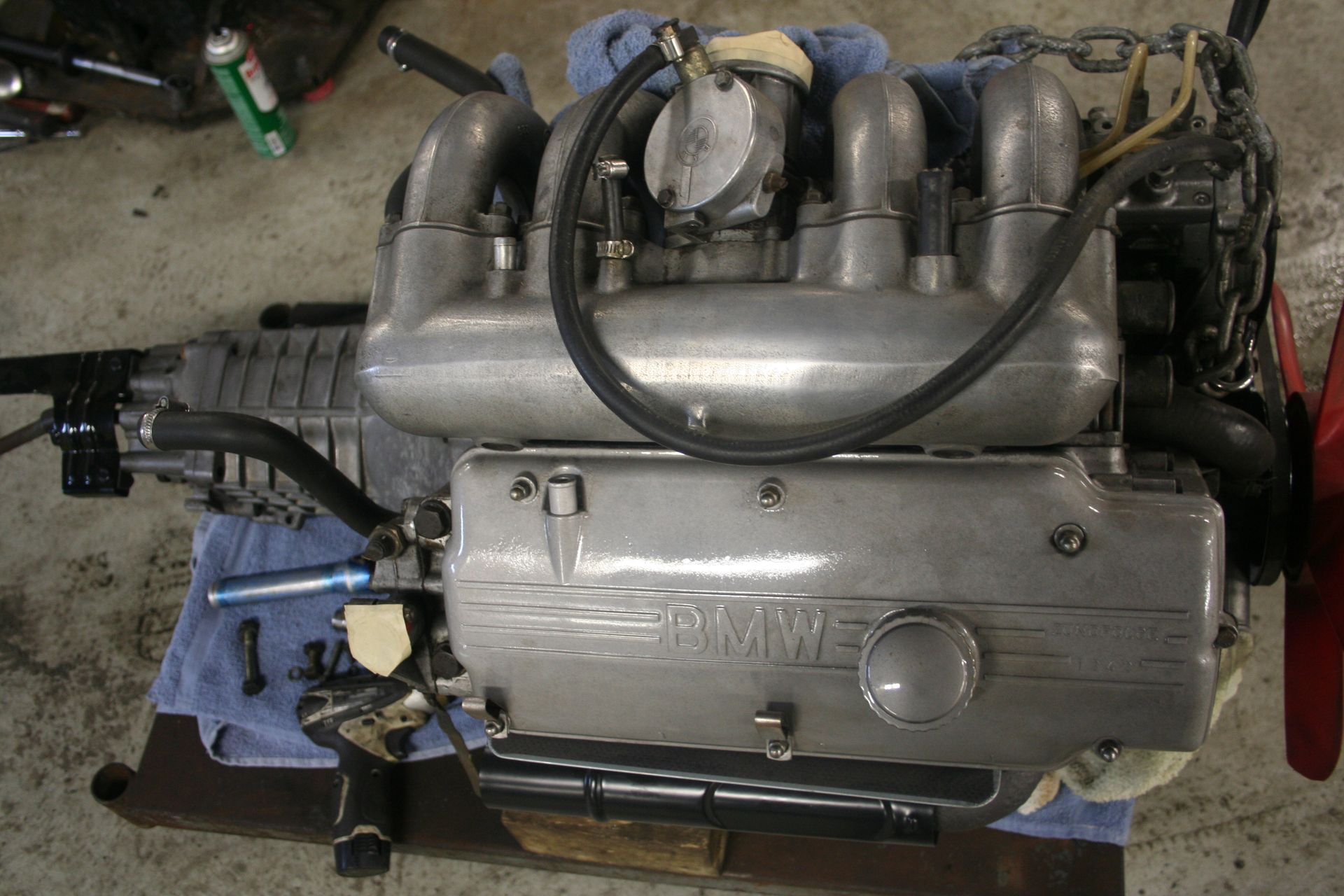 Silver BMW engine on a workbench, with intake manifold and valve cover visible. | Autobahn Performance Inc