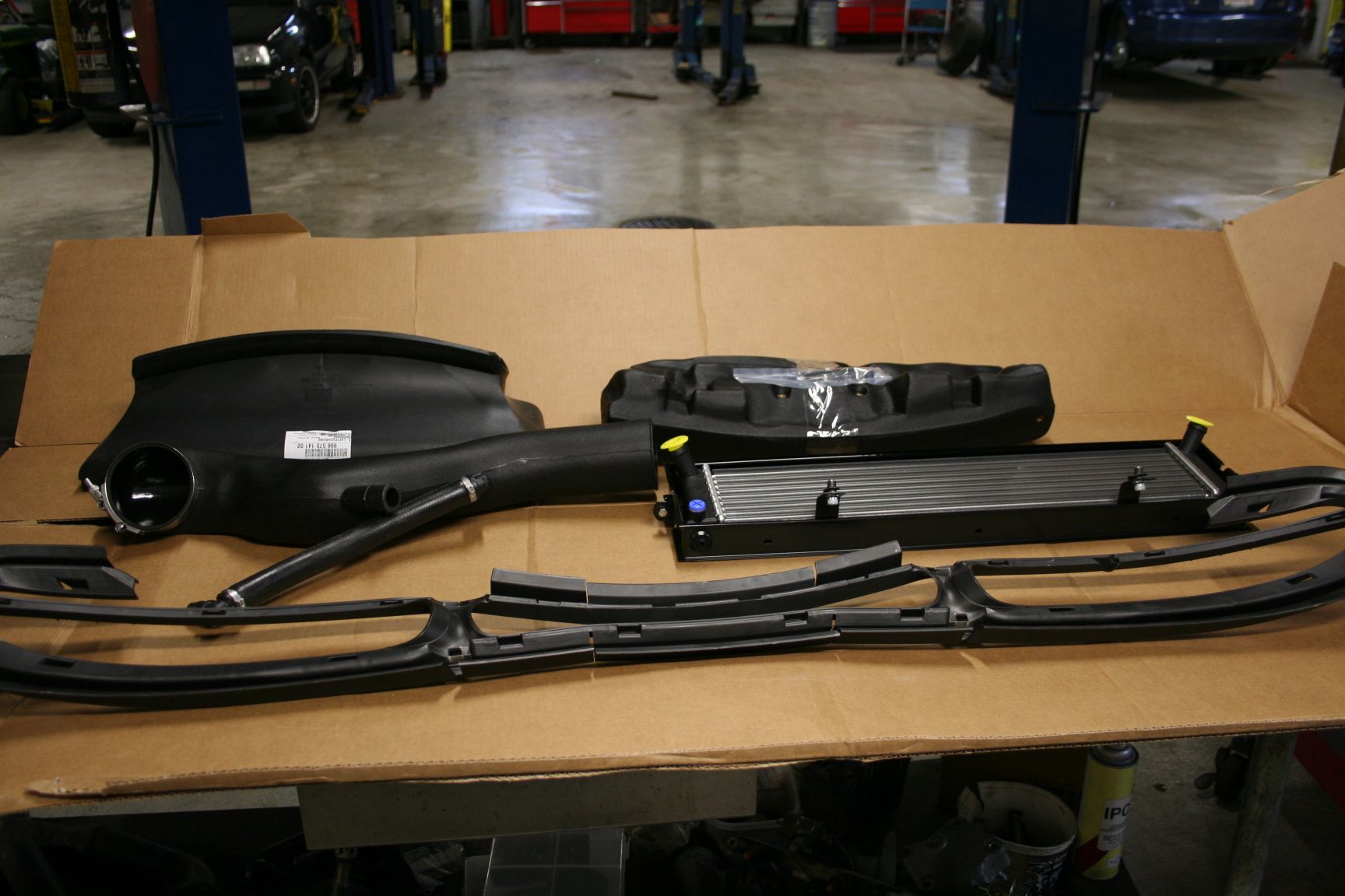Car dashboard parts laid out on cardboard in a garage. | Autobahn Performance Inc