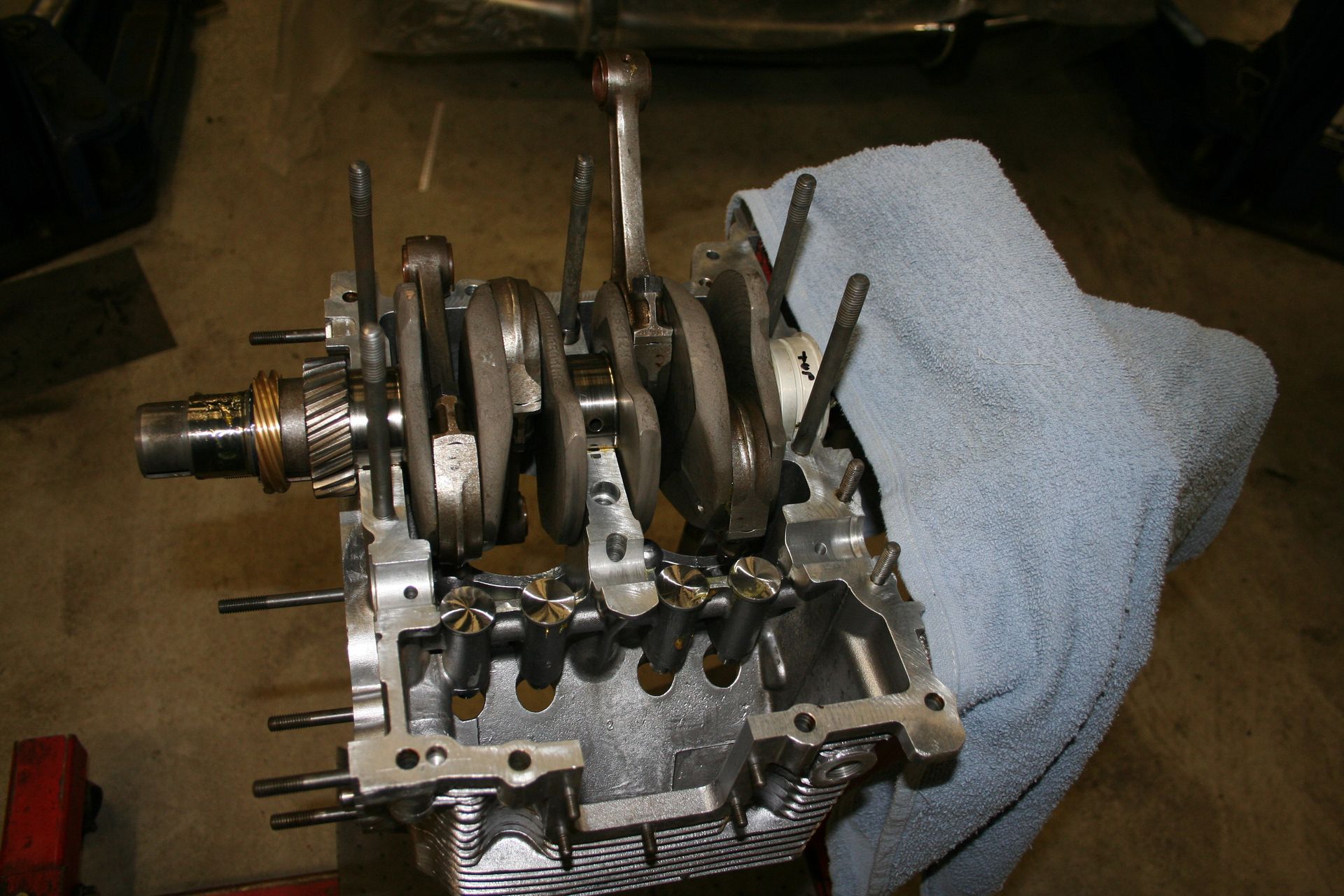 Engine block with crankshaft and connecting rods exposed, resting on a surface. Covered by a blue cloth. | Autobahn Performance Inc