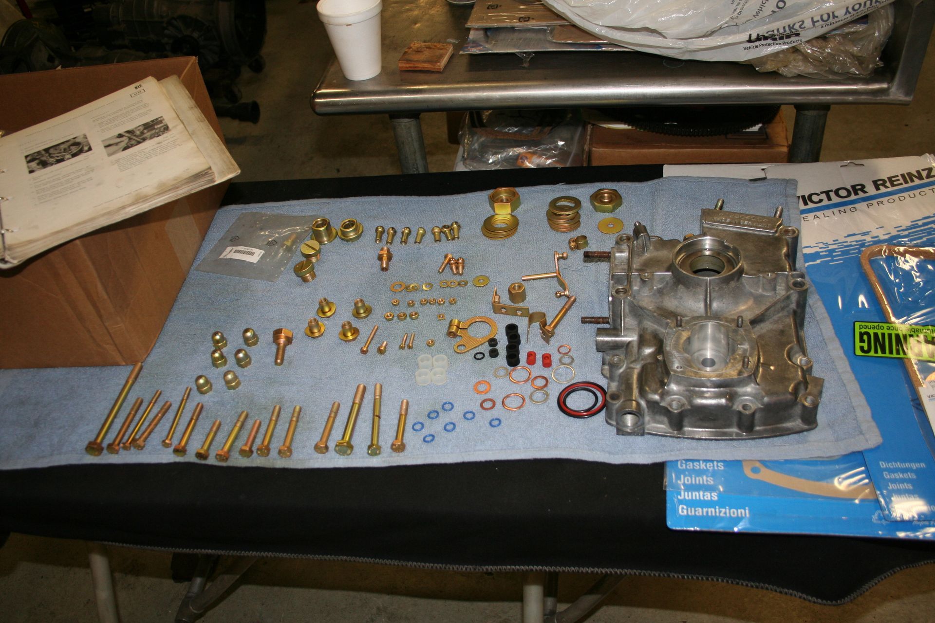 Disassembled carburetor parts and components laid out on a blue cloth. | Autobahn Performance Inc
