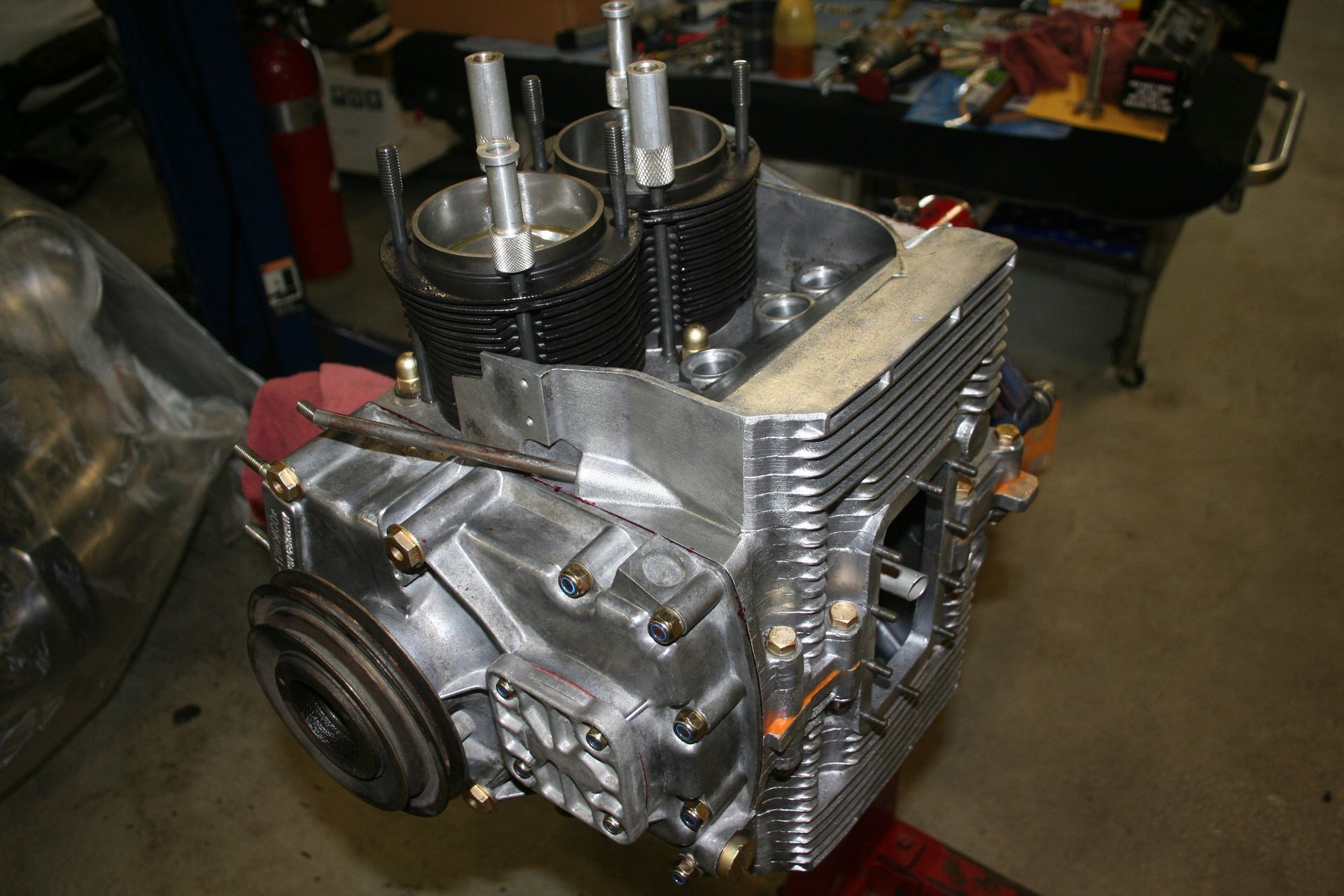 Engine block with two cylinders and cooling fins, on a workbench. | Autobahn Performance Inc