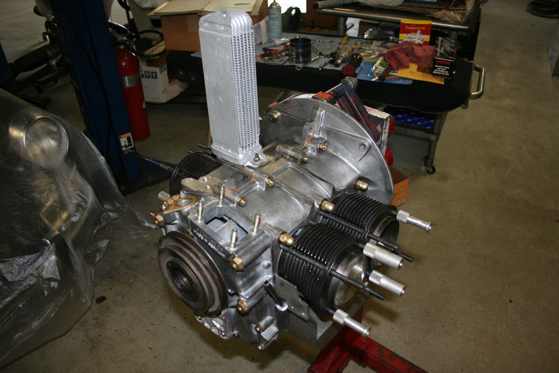 Close-up of a partially assembled, silver air-cooled engine with cylinders, likely for a vehicle, on a work stand. | Autobahn Performance Inc