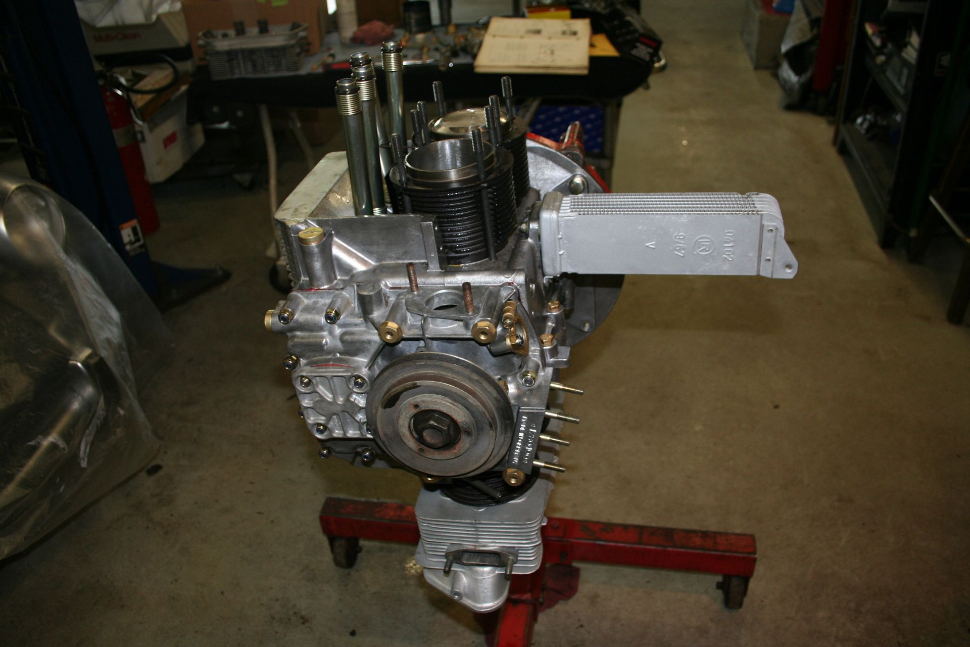 Engine block on a red stand, in a garage. Metal components are visible. | Autobahn Performance Inc