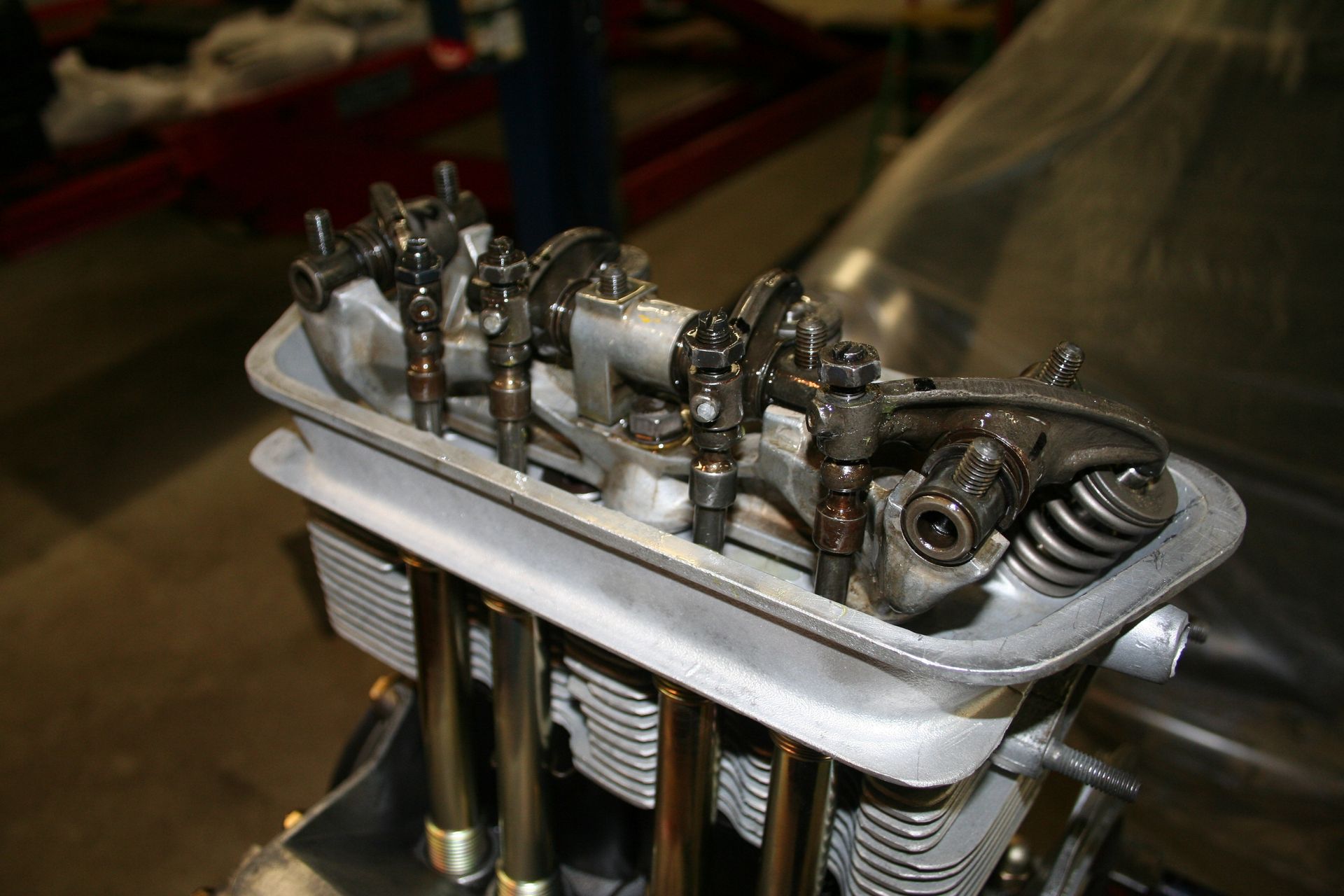 Close-up of a disassembled engine head, showing valves, fuel injectors, and rocker arms, likely for repair or modification. | Autobahn Performance Inc