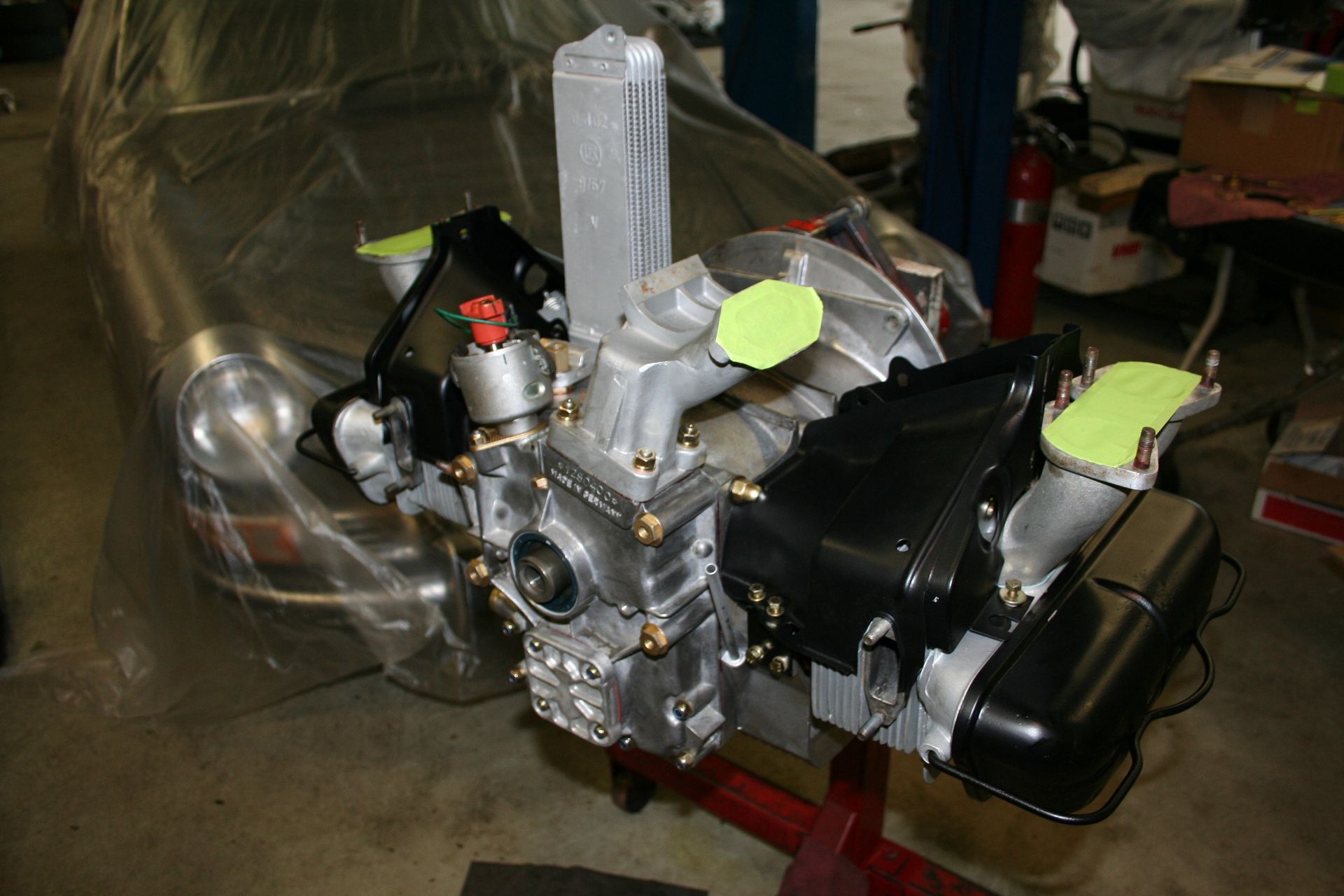 An engine, with silver and black components, is wrapped in plastic. | Autobahn Performance Inc