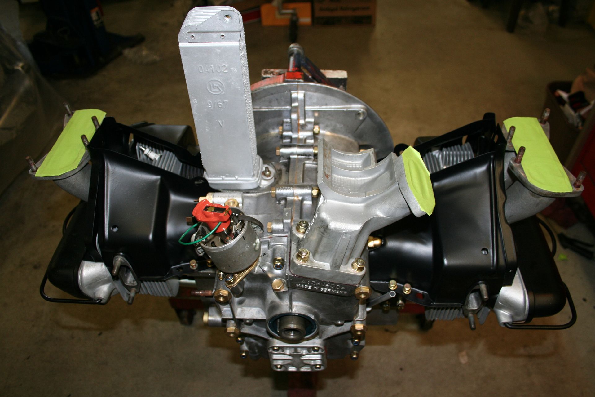 Engine, likely for a vehicle, with silver and black components and a central distributor. | Autobahn Performance Inc
