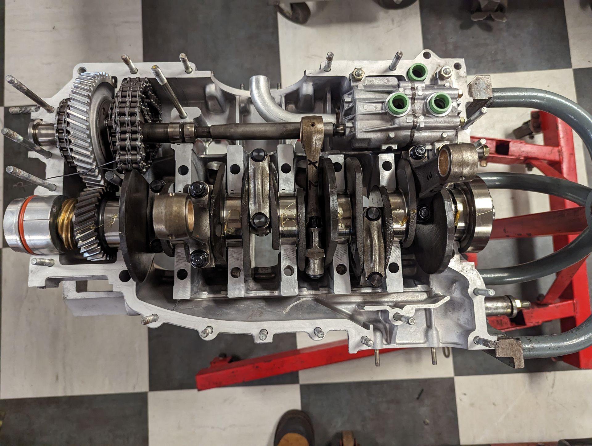 Partially disassembled car engine on a red stand; interior view. Crankshaft, pistons, chains and other components visible. | Autobahn Performance