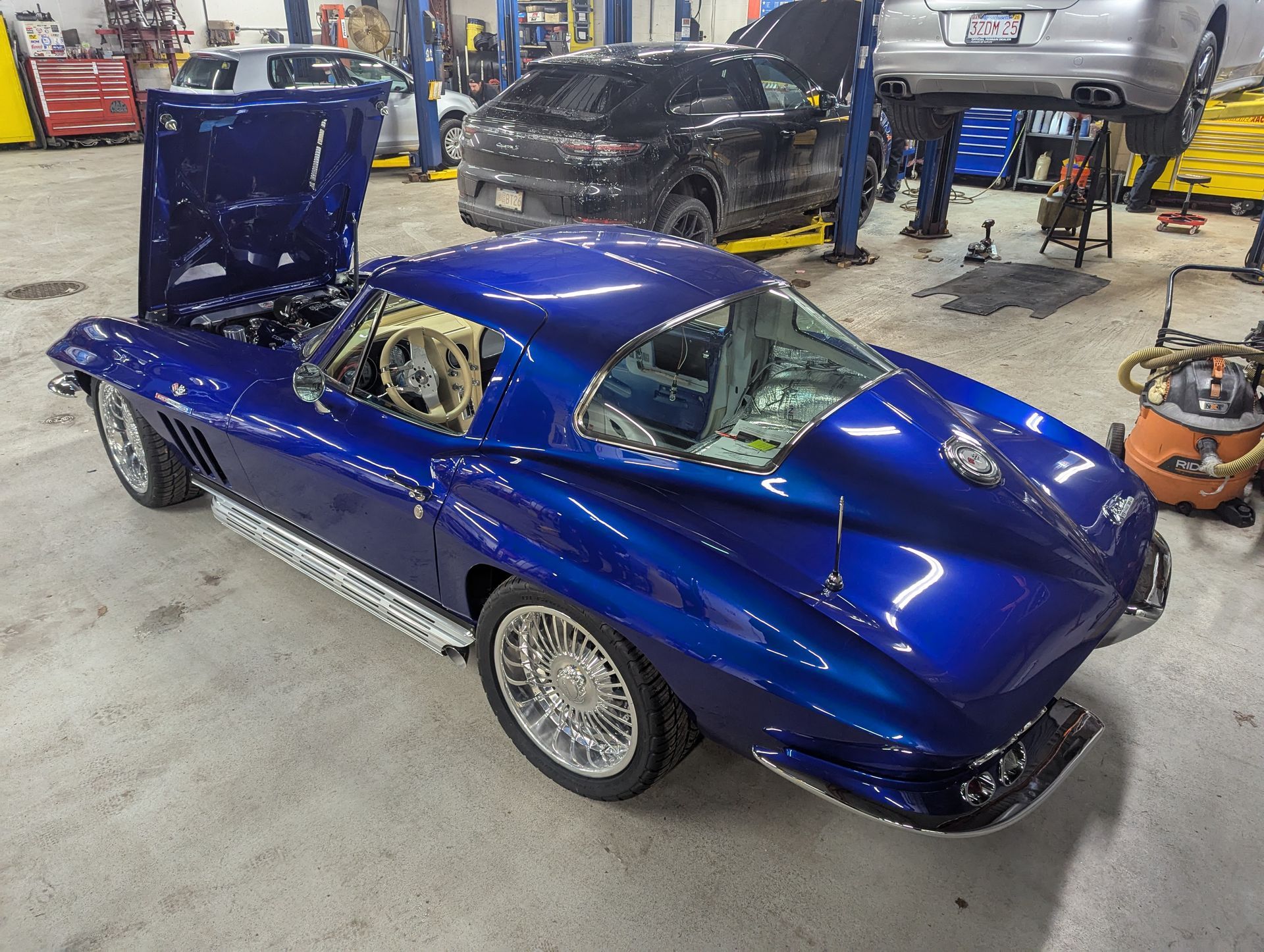 Blue classic Corvette with open hood in a garage. | Autobahn Performance Inc