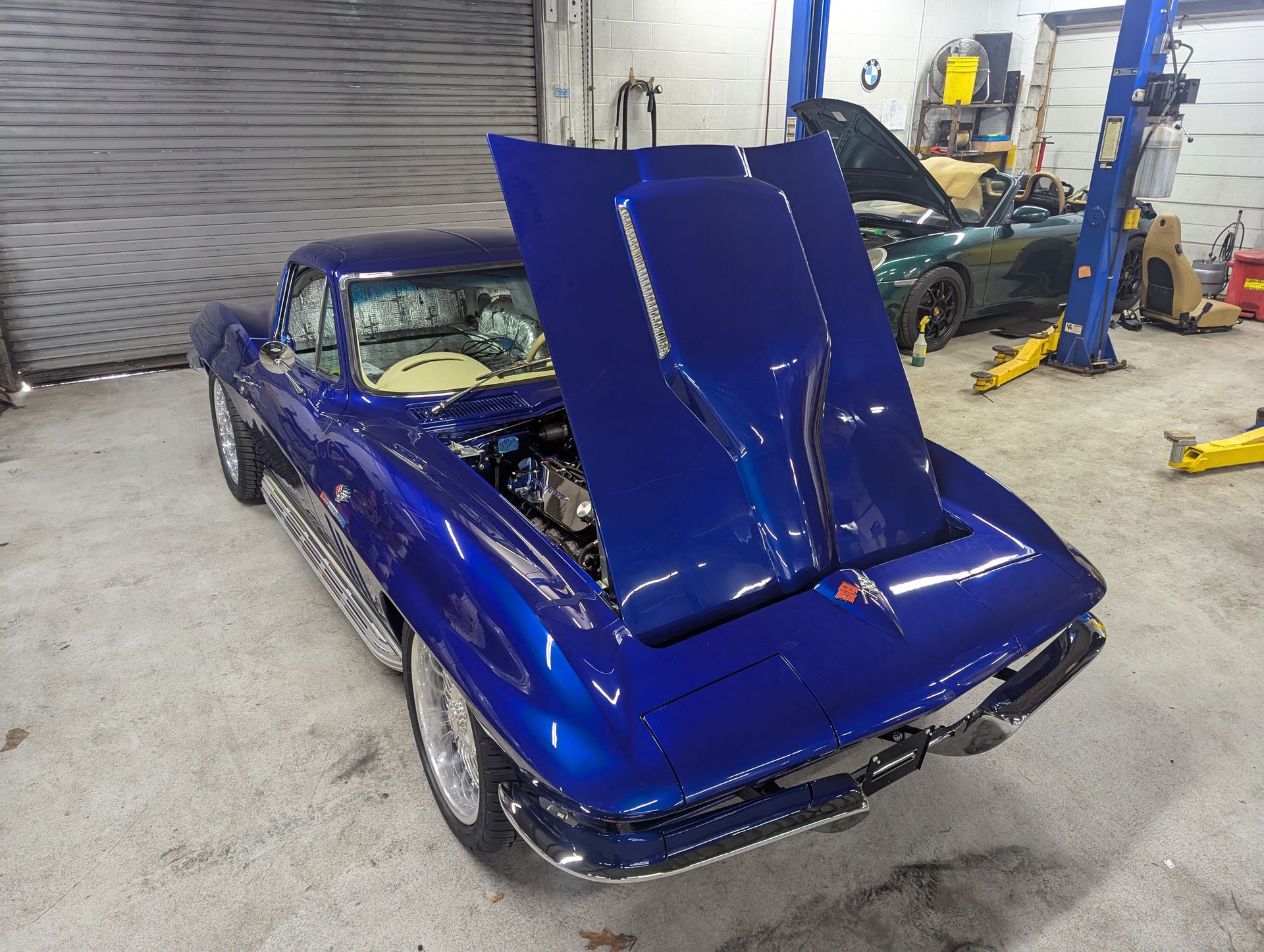 Blue classic Corvette with hood open, in a garage. | Autobahn Performance Inc