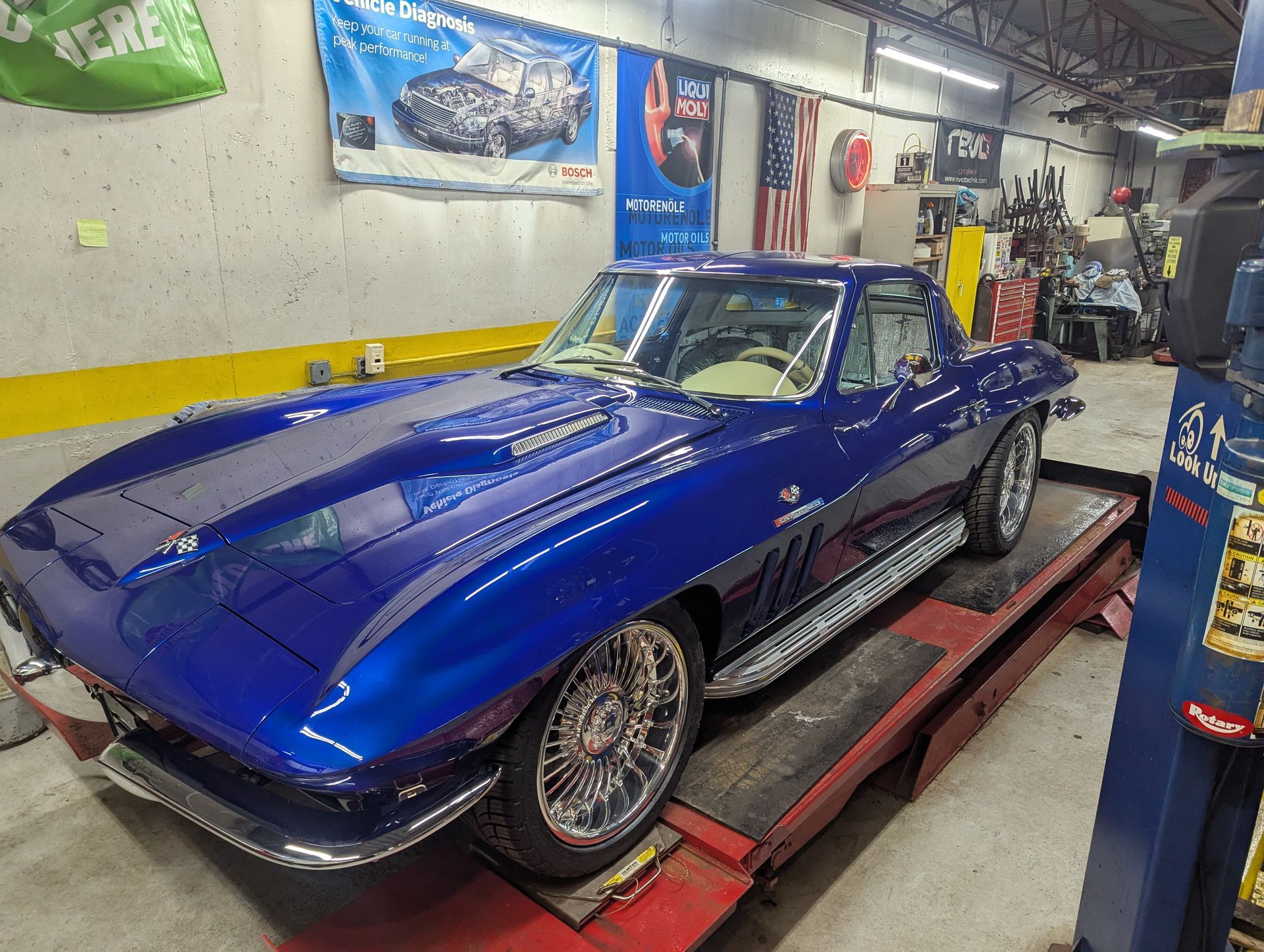 Blue classic Corvette on a car lift in a garage. | Autobahn Performance Inc