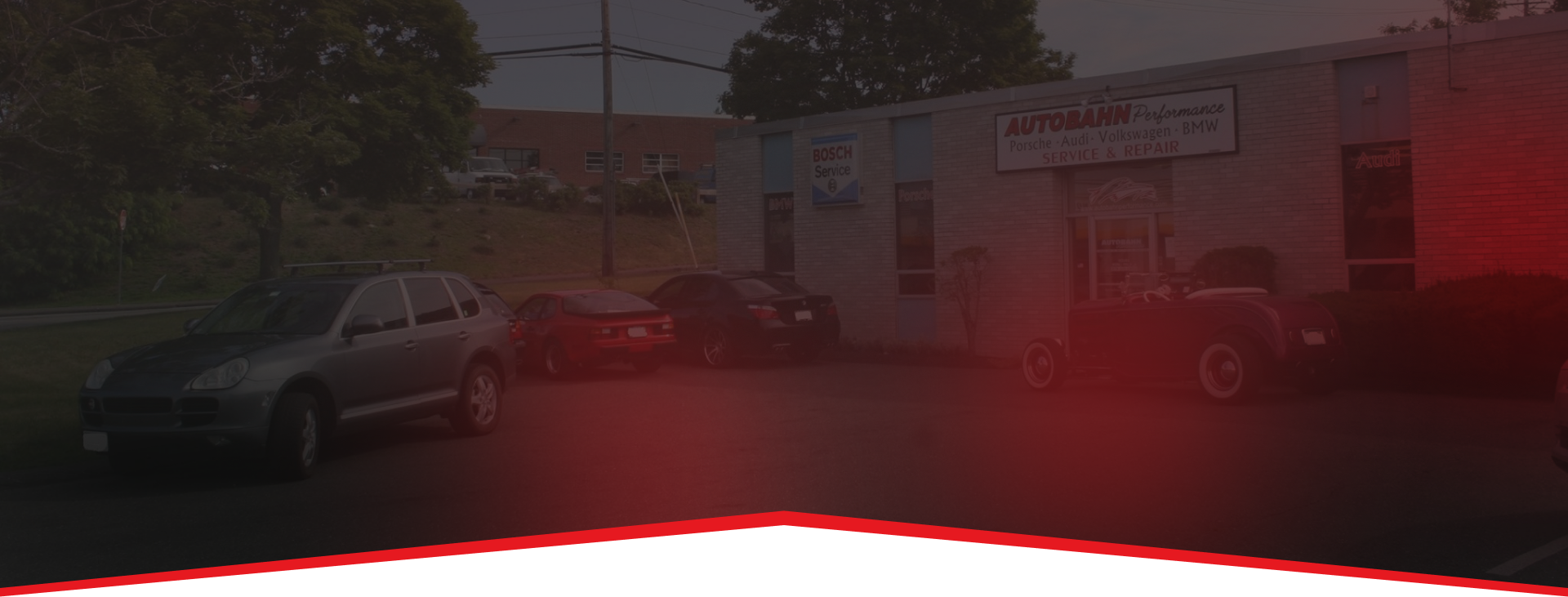 Cars parked in front of a light-colored building. | Autobahn Performance Inc