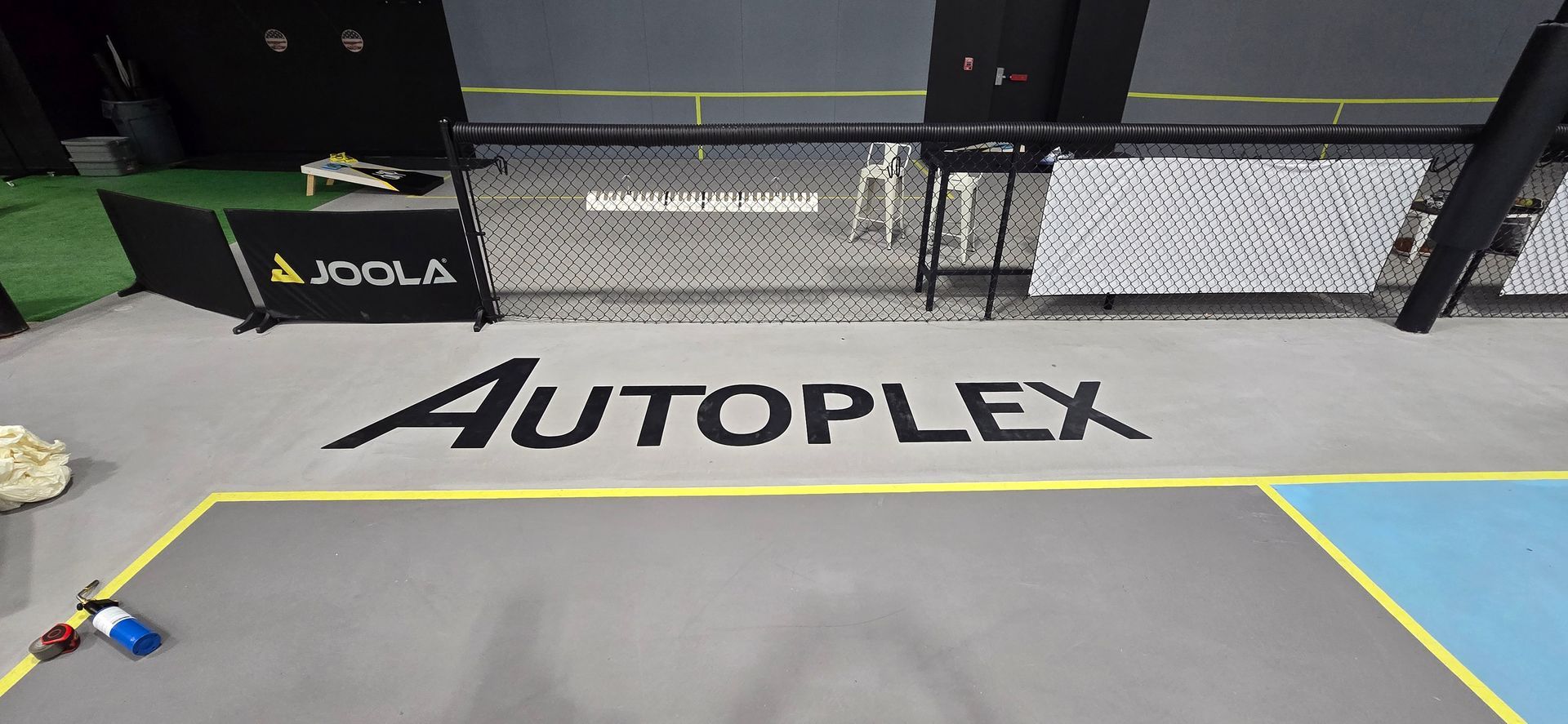 The word autoplex is painted on the floor of a gym