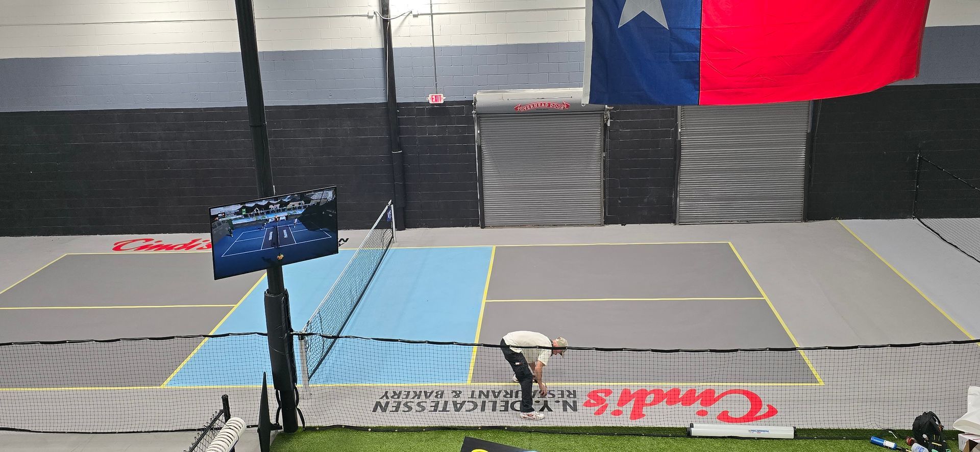 An aerial view of a tennis court with a red and blue flag