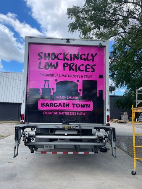 A bargain town truck is parked in a parking lot