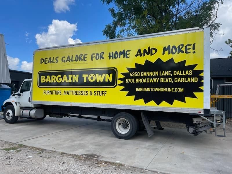 A bargain town truck is parked in a parking lot