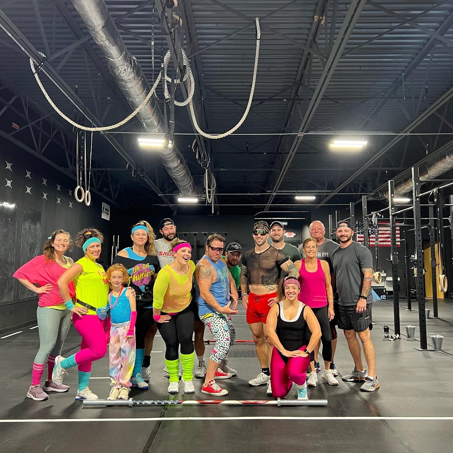 A woman is doing push ups with dumbbells in a gym.