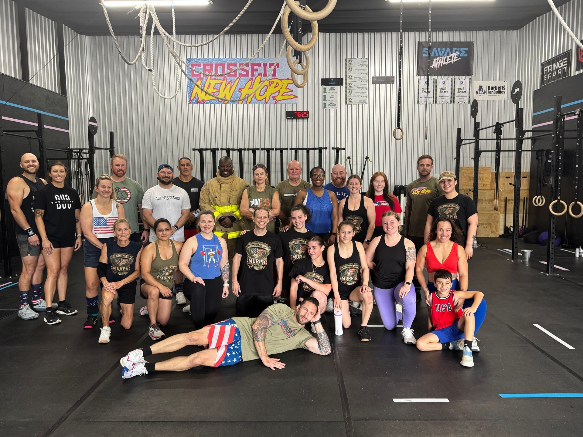 A man is pushing a tire in a gym.