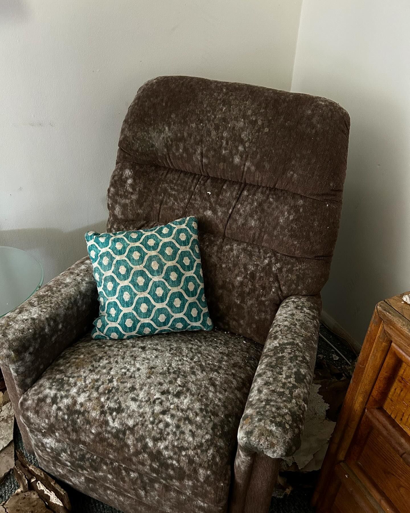 A brown chair with a blue pillow on it