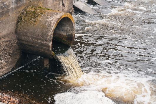 A pipe is draining water into a river.