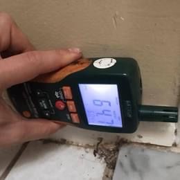 A person is holding a digital thermometer in their hand.