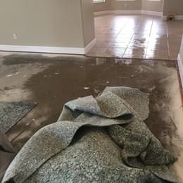 A pile of carpet is laying on the floor in a living room.