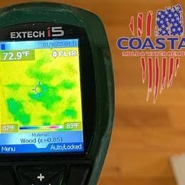 A thermal camera is sitting on top of a wooden table.