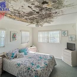 A bedroom with a bed , dresser , television and a ceiling fan.