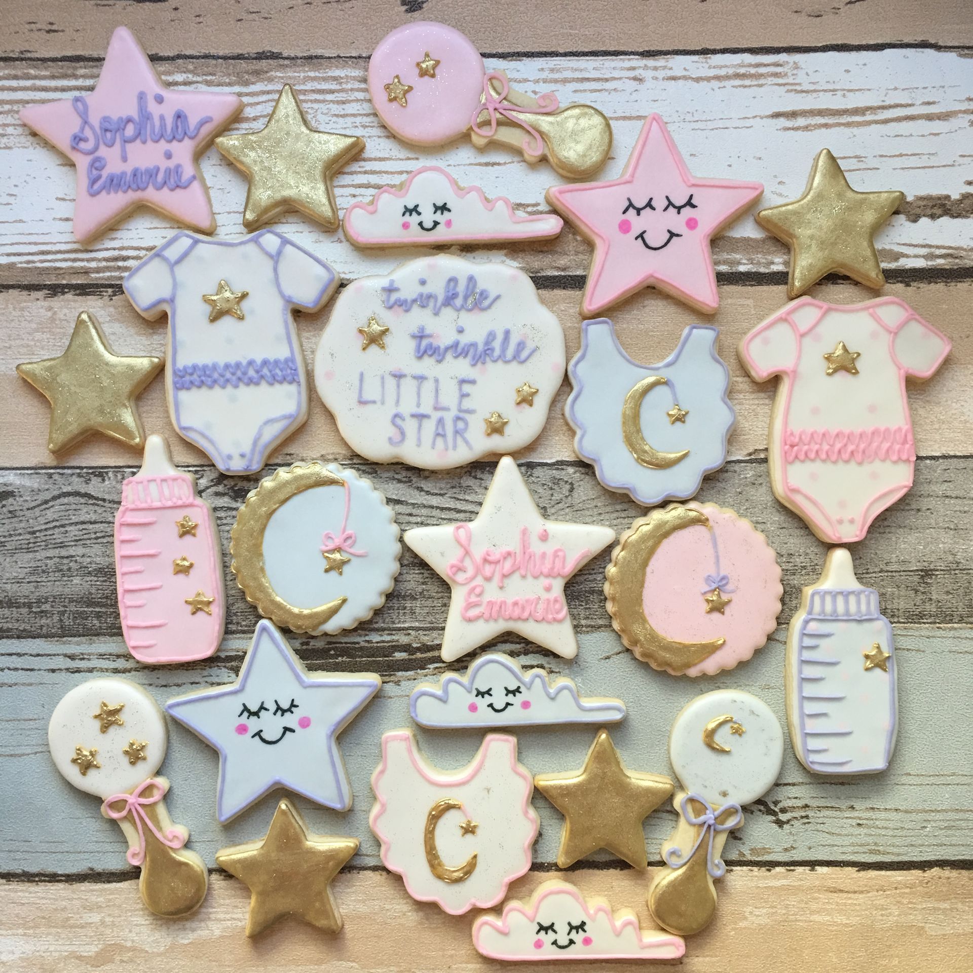 Baby shower cookies: stars, clouds, baby clothes, bottles, rattles, and crescent moons in pastel colors.