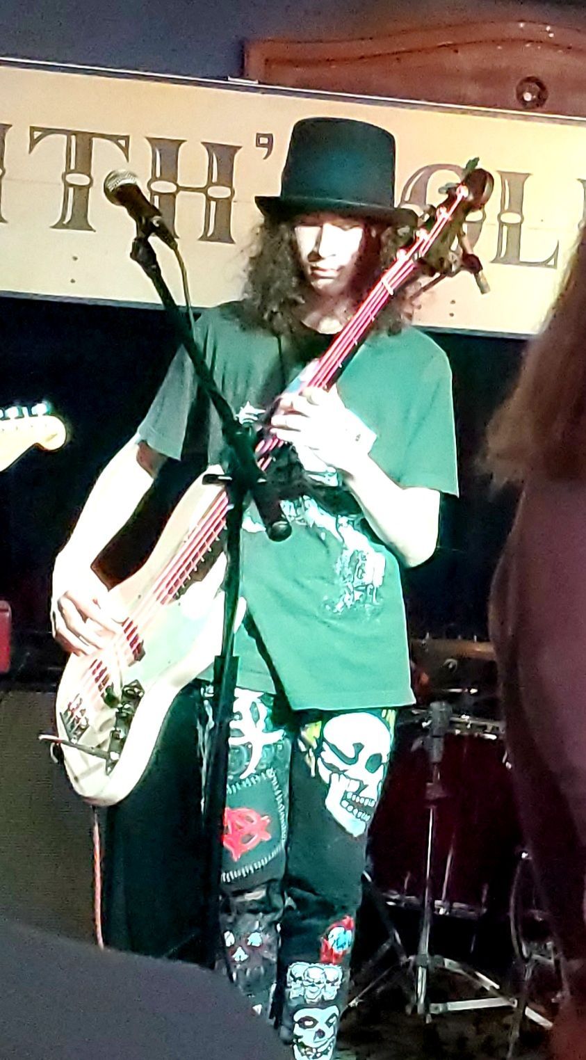 Playing my bass with pink strings and a top hat