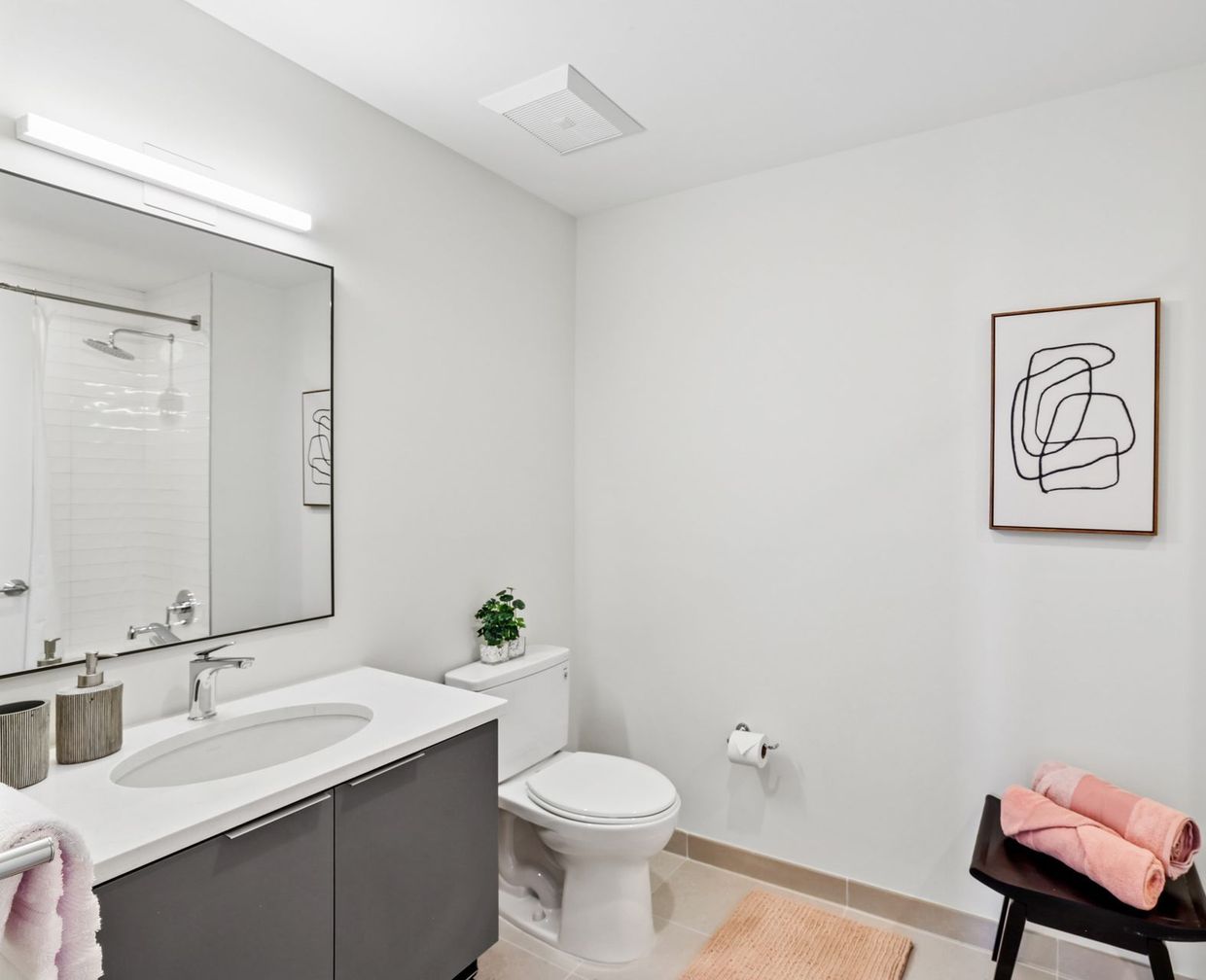 A bathroom with a toilet , sink and mirror.