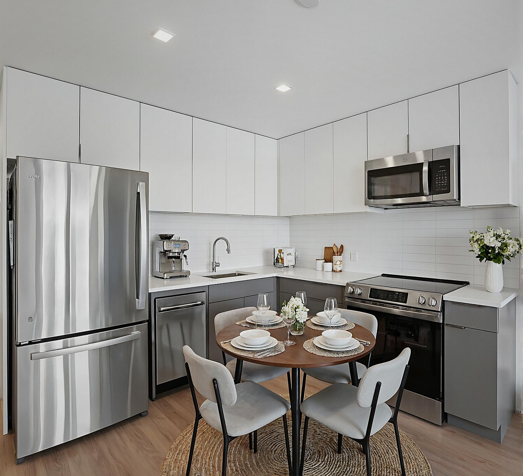 A kitchen with stainless steel appliances and gray cabinets