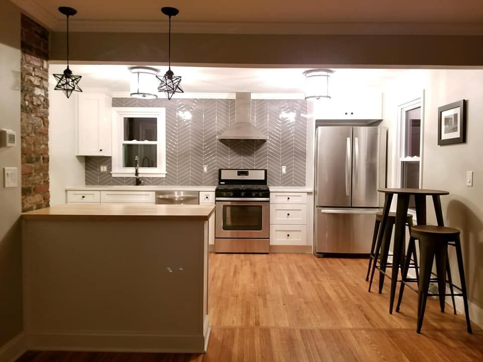 A kitchen with stainless steel appliances and wooden floors