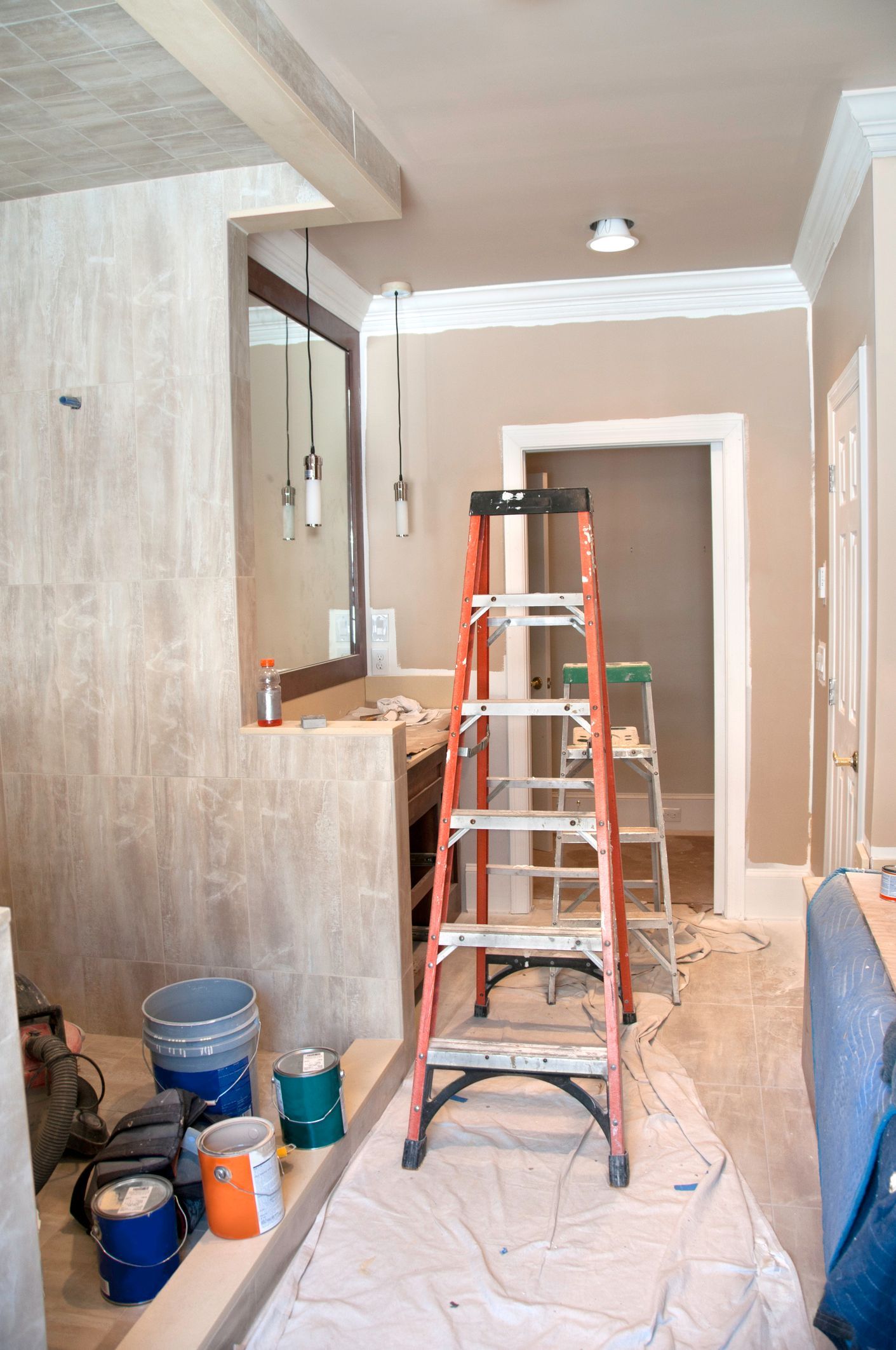 In-progress picture of the remodeling of a master bathroom, with a stepladder in the middle.